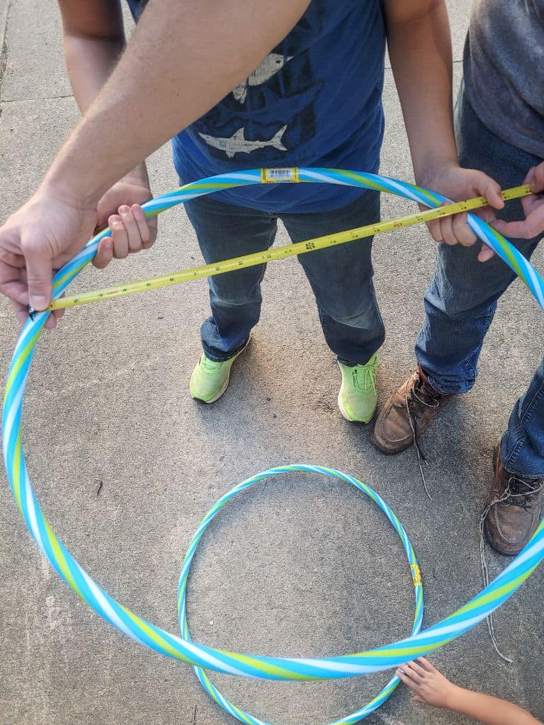 photo of people measuring a plastic hoop