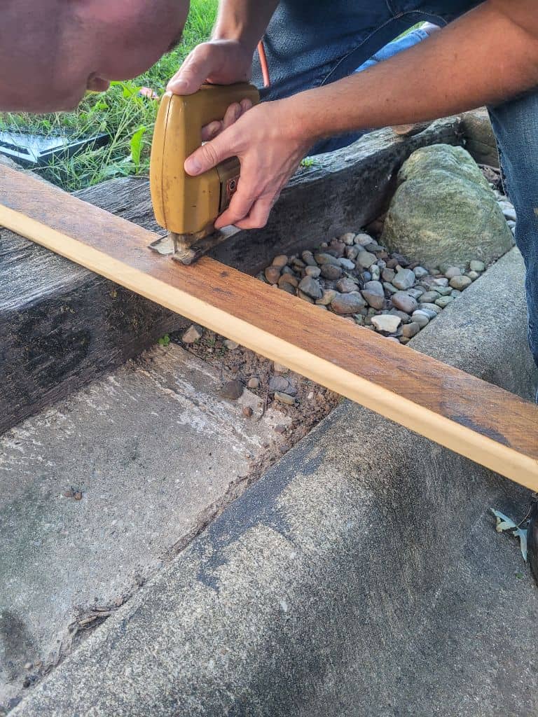 photo of a man cutting a board with a jigsaw