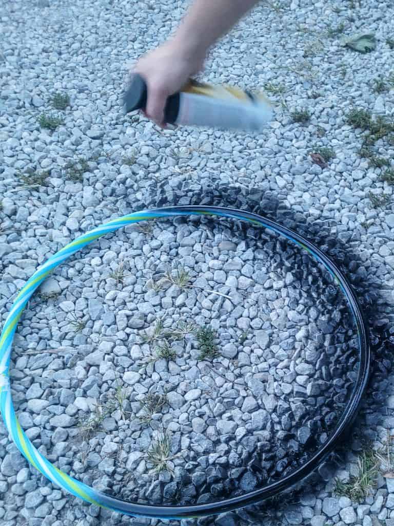 photo of a man spray painting a plastic hoop