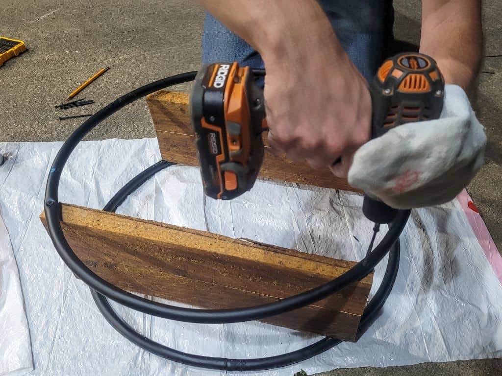 photo of a man drilling screws into a hoop book shelf